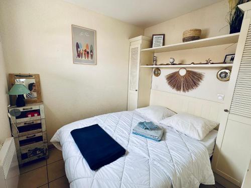 um quarto com uma cama com uma toalha azul em Appartement rez-de-chaussée entre dunes et ocean em Lacanau-Océan