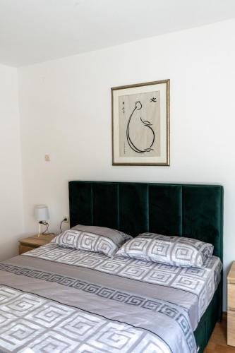 a bed with a green headboard in a bedroom at Apartment in City Center of Skopje in Skopje