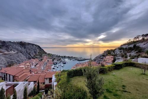a view of a town on a hill next to the water at Portopiccolo Apartments in Sistiana