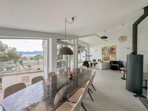 une salle à manger avec une table et une grande fenêtre dans l'établissement Villa du Soleil - Cannes, à Cannes