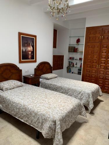 a bedroom with two beds and a chandelier at LA BARRACA - A - Relax, Terraza cerca del mar in Mojácar