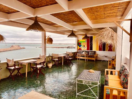 un restaurante con mesas y sillas y vistas al océano en Art riad au bord de la mer 2, en El Jadida