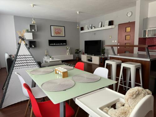 a living room with a green table and chairs at Rodinný apartmán v srdci Piešťan in Piešťany