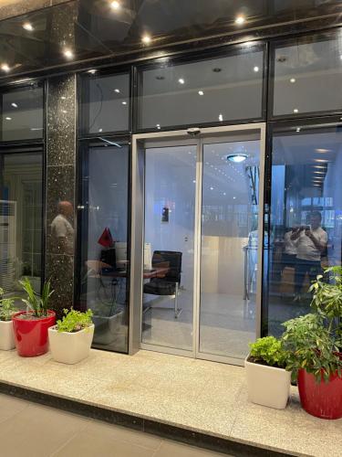an office with glass doors and potted plants at Riverside rooms at Hotel Fieri in Fier
