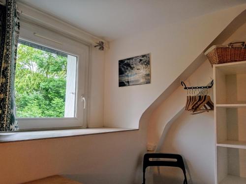 un escalier avec une fenêtre et une chaise dans une pièce dans l'établissement L idéal 10 mn Vannes Linge de lit, serviettes inclus wifi parking gratuit, à Noyalo