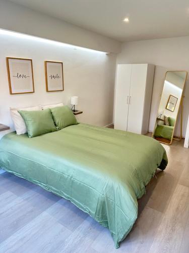 1 dormitorio con 1 cama verde grande en una habitación en Apartamento em Cascais, en Cascais