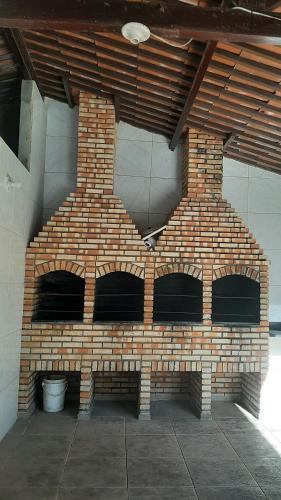 a brick oven in a room with a brick wall at Kite house - prox do Cumbuco in Caucaia