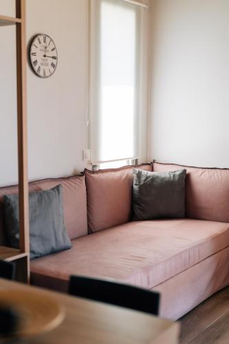 a couch in a living room with a clock on the wall at Apolithon Premium Houses in Sígrion