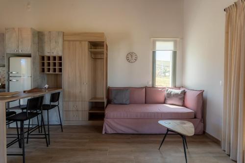 a living room with a pink couch and a kitchen at Apolithon Premium Houses in Sígrion