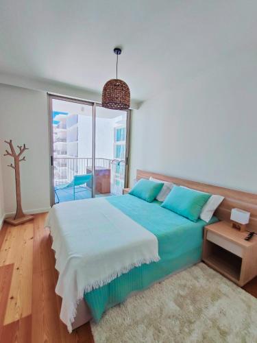 a bedroom with a large bed and a large window at Bayline- Beachfront and Pool in Armação de Pêra