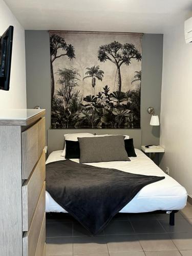 una camera da letto con un grande letto e un dipinto sul muro di Hotel Cote et Lac a Biscarrosse