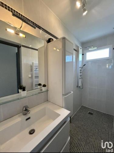 a white bathroom with a sink and a shower at Chez nous in Fleury