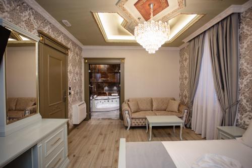 a living room with a couch and a chandelier at Ervini Boutique Hotel in Shkodër