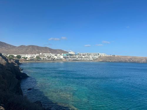 a large body of water with a city in the background at VILLA BARRACUDA - "Seaview 3min walk to the beach" in Playa Blanca