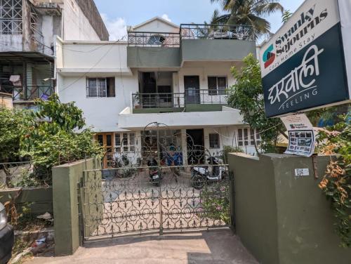 a building with a gate and a sign in front of it at Swanky Sojourns Cosy Home Stay in Kolhapur