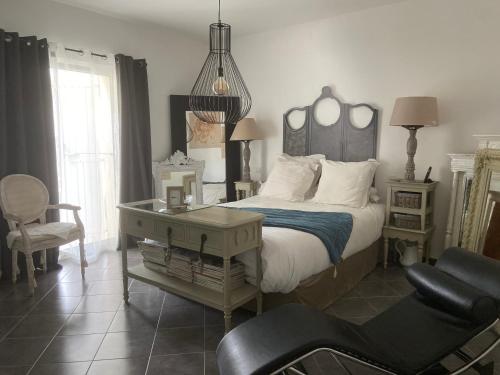 - une chambre avec un lit, un bureau et une chaise dans l'établissement Villa Saint Marc Jaumegarde proche de la Sainte Victoire, à Saint-Marc-Jaumegarde