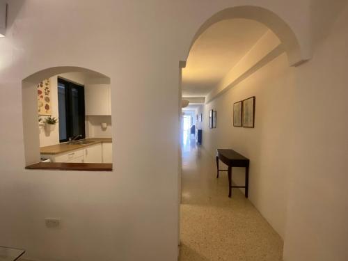 Tal-GħoqodにあるSt Julians Property with Terraceのテーブルと洗面台のある廊下に通じるアーチ道