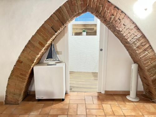 an archway in a room with a refrigerator and a door at Gli archi nel cuore di Siena in Siena