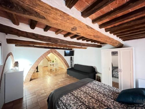 a bedroom with a bed and a living room at Gli archi nel cuore di Siena in Siena