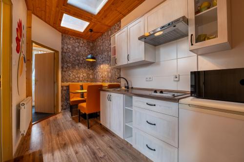 a kitchen with white cabinets and a table and chairs at Penzion Fortuna in Liptovský Mikuláš
