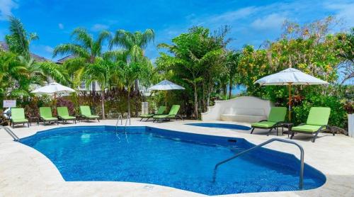 a pool with chairs and umbrellas in a resort at Blue Horizon Battaleys Mews Mullins Barbados in Saint Peter