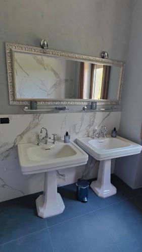 a bathroom with two sinks and a mirror at Villa Giordana in Casalborgone