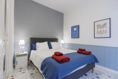 a bedroom with a bed with two red pillows on it at Dimore Italiane - Private Suites in Corralejo