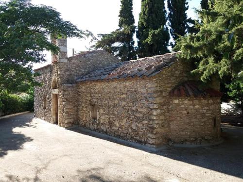 a stone building with a stone wall at Melina Apartment - Akoumia Village in Akoumia