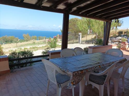 a table and chairs on a patio with a view of the ocean at La Terrazza su Pispisa in Castellammare del Golfo