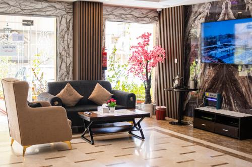salon z kanapą i telewizorem w obiekcie Best Trip Serviced Apartments w mieście Dżudda