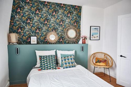 - une chambre avec un lit orné d'un papier peint floral dans l'établissement Charmante maison de bord de mer, à Houlgate