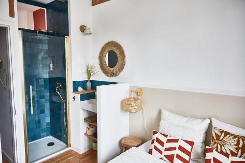 - une chambre avec une douche et un lit avec des oreillers dans l'établissement Charmante maison de bord de mer, à Houlgate