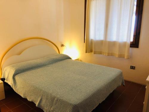 een slaapkamer met een bed met een blauwe deken erop bij Villetta Bouganville vista mare in Porto Ottiolu