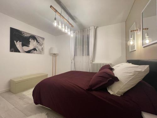 a bedroom with a bed with purple sheets and pillows at Pyrenair location Maison 8 personnes proche des télécabines in Luchon