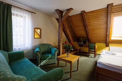 a hotel room with a couch and a bed and a table at Hotel U Lípy in Krušovice