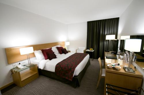 a hotel room with a bed and a desk at Amman Airport Hotel in Al Qasţal