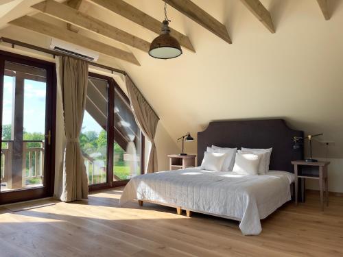 a bedroom with a bed and a large window at Karlamuiza Country Hotel in Kārļi