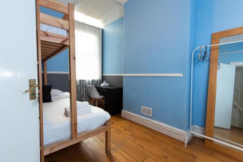 Suite 1 - Cosy Room Close to MCR City Centre في مانشستر: غرفة نوم مع سرير بطابقين وجدار ازرق