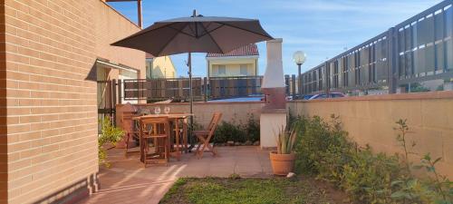 a patio with a table and an umbrella at Casa Totò in Venturina Terme