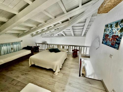 a bedroom with two beds in a room with wooden floors at L'attico del porto in Porto Rotondo