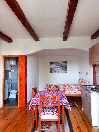 a room with a table and a bed and a bathroom at Domaćinstvo Krstajić - Rural holiday in Žabljak