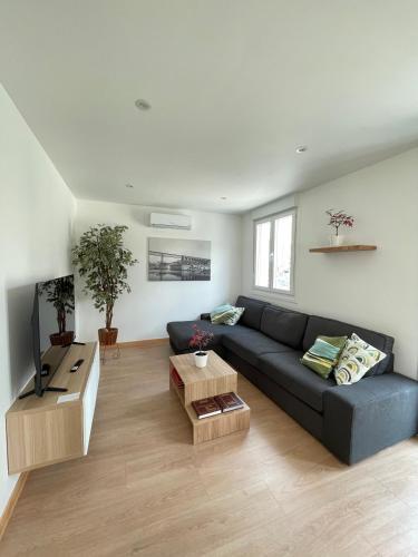 a living room with a blue couch and a table at Apartamentos A Xunqueira in Redondela