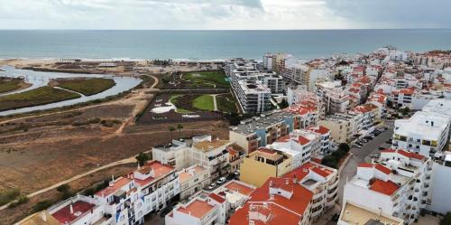 eine Luftansicht auf eine Stadt und das Meer in der Unterkunft Apartamento Cristina - Próximo da praia in Armação de Pêra