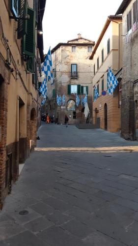 an empty street with blue and white flags in an alley at Gli archi nel cuore di Siena in Siena