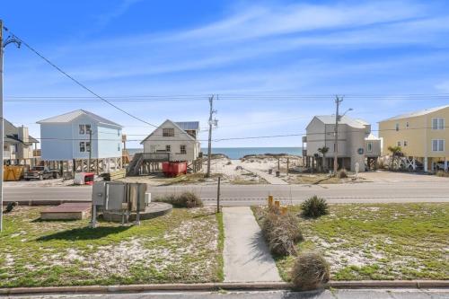 a street with houses and the ocean in the background at Sea Oats 102C- Beach view Pool 25 steps to beach in Gulf Shores