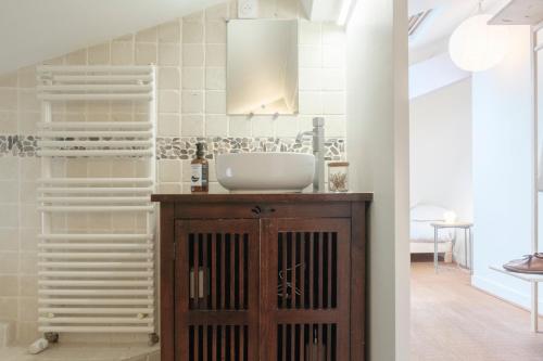La salle de bains est pourvue d'un lavabo et d'une armoire en bois. dans l'établissement Casa Champgil, à Clermont-Ferrand