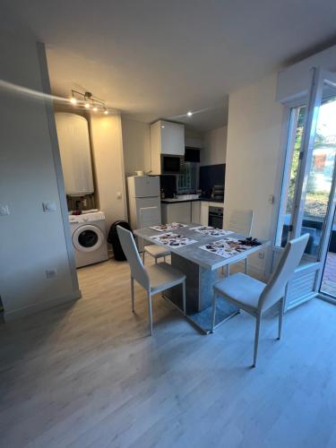 une cuisine avec une table et des chaises dans une pièce dans l'établissement Appartement avec place de parking privé et jardin, à Beaumont-sur-Oise