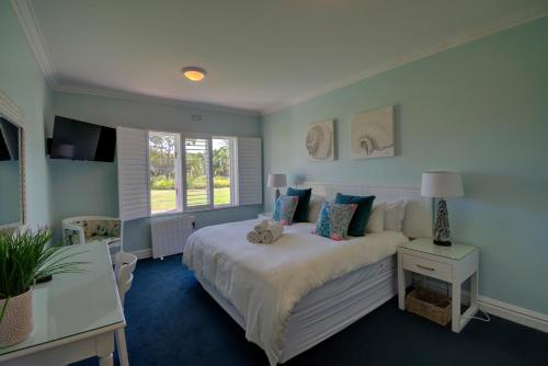 1 dormitorio con cama, mesa y ventana en Keurbooms River Lodge 21, en Keurboomstrand