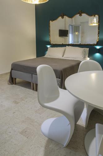 a bedroom with a bed and a table and a mirror at B&B Sbarco dei 1000 Marsala in Marsala