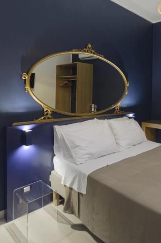 a bedroom with a large mirror above a bed at B&B Sbarco dei 1000 Marsala in Marsala